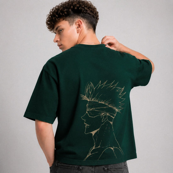 Person wearing a green t-shirt with a design on the back, standing against a gray background
