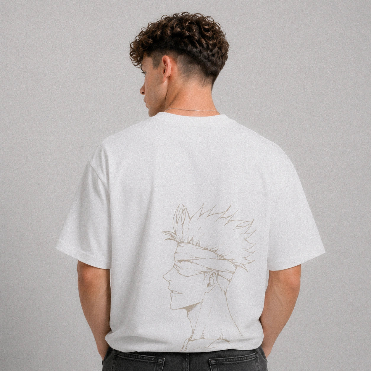 Person wearing a white t-shirt with a graphic design on the back against a gray background