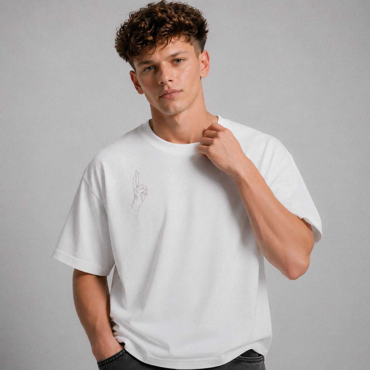 Man wearing a white t-shirt with a small design on a gray background