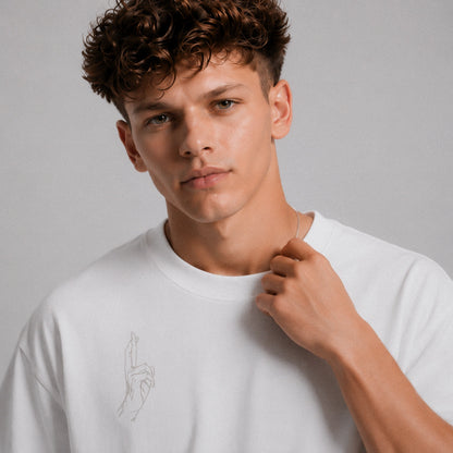 Man wearing a white t-shirt with a small design on a gray background
