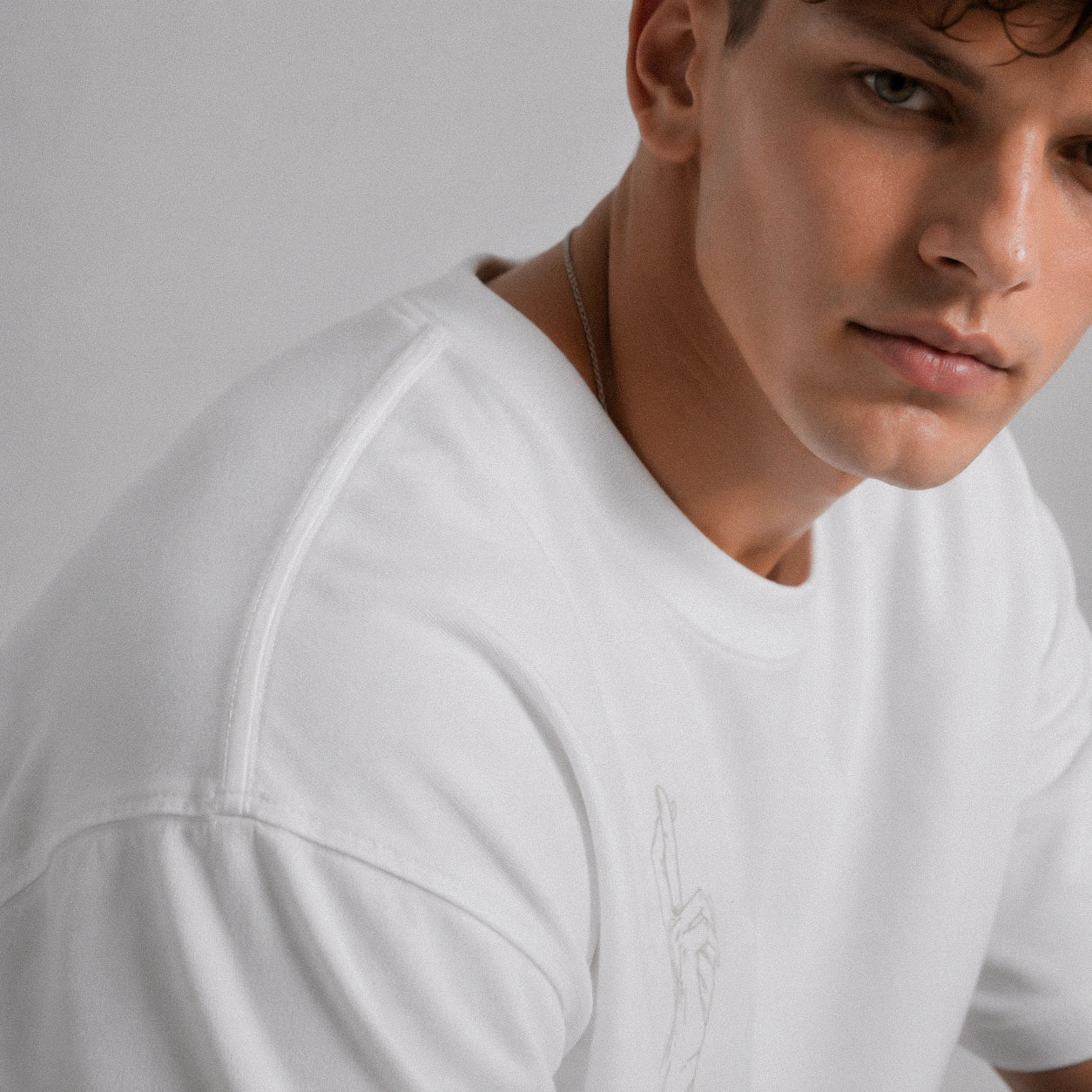 Man wearing a white t-shirt against a plain background