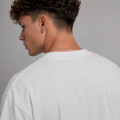 Person wearing a white shirt against a gray background