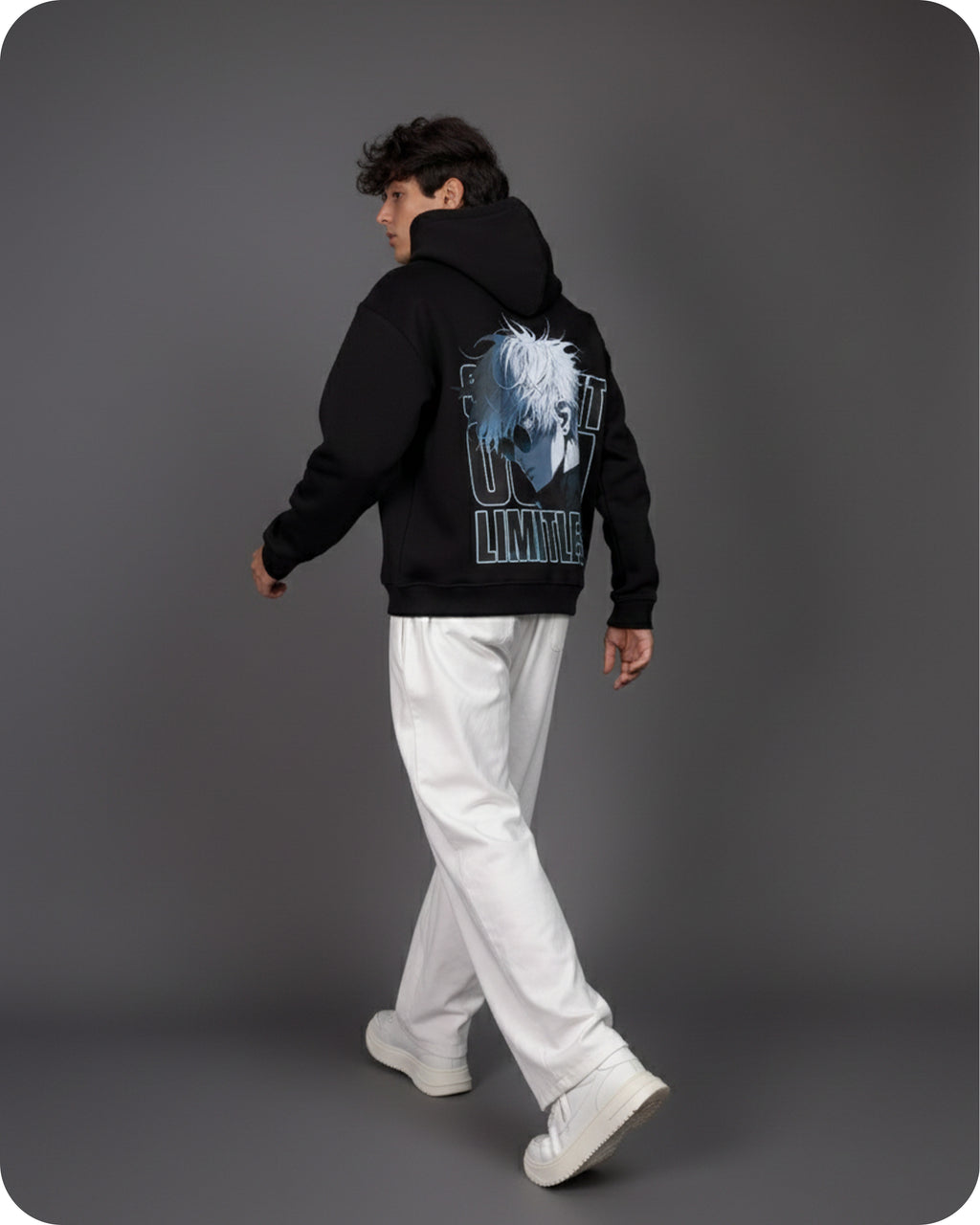 Person wearing a black hoodie with a graphic design on the back against a gray background