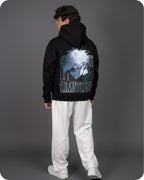 Person wearing a black hoodie with a graphic design on the back against a gray background