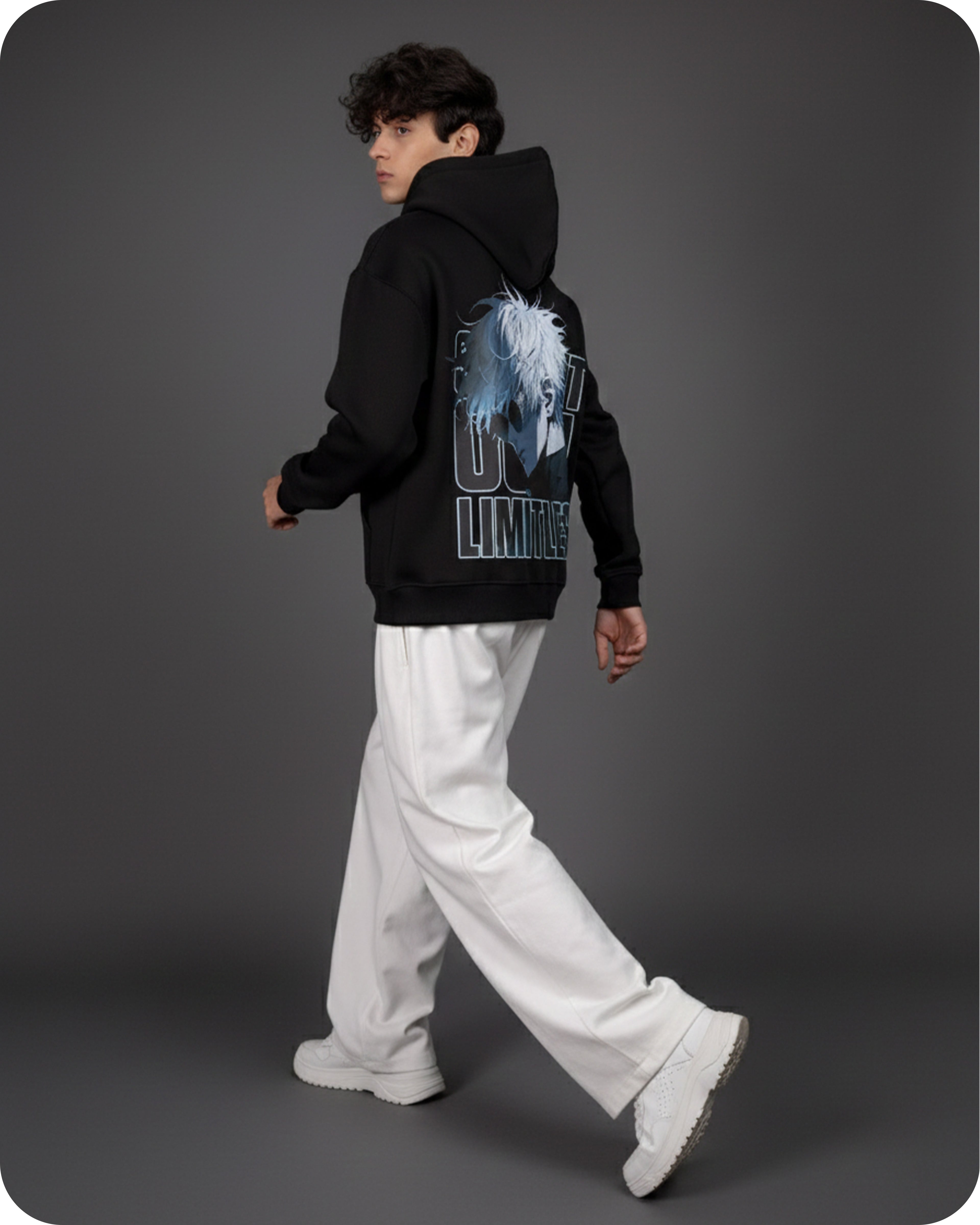 Person wearing a black hoodie with a graphic design on the back against a gray background