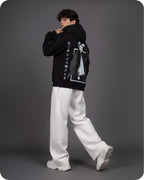 Person wearing a black hoodie with white text and graphics on a gray background