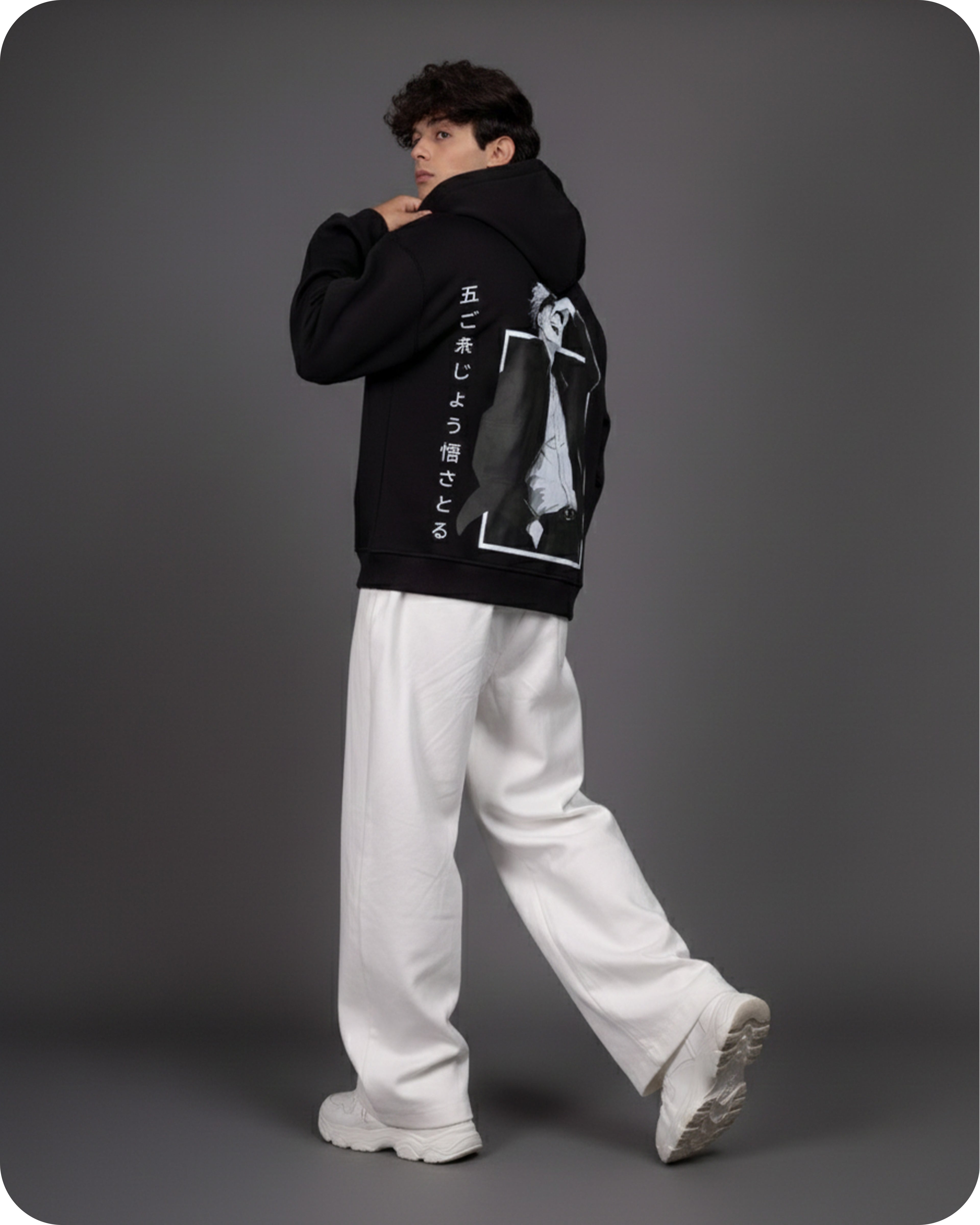 Person wearing a black hoodie with white text and graphics on a gray background