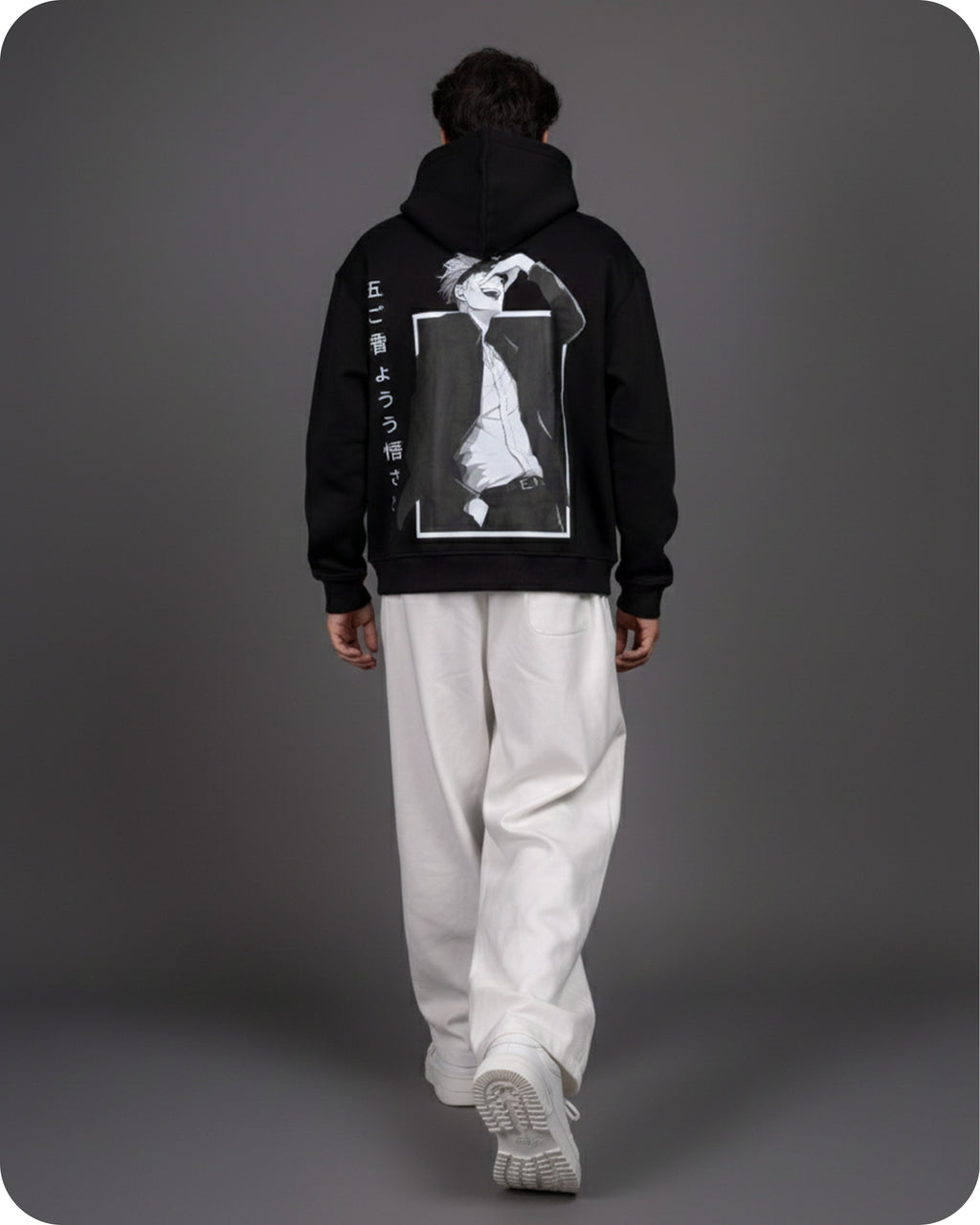 Person wearing a black hoodie with a graphic design on the back against a gray background