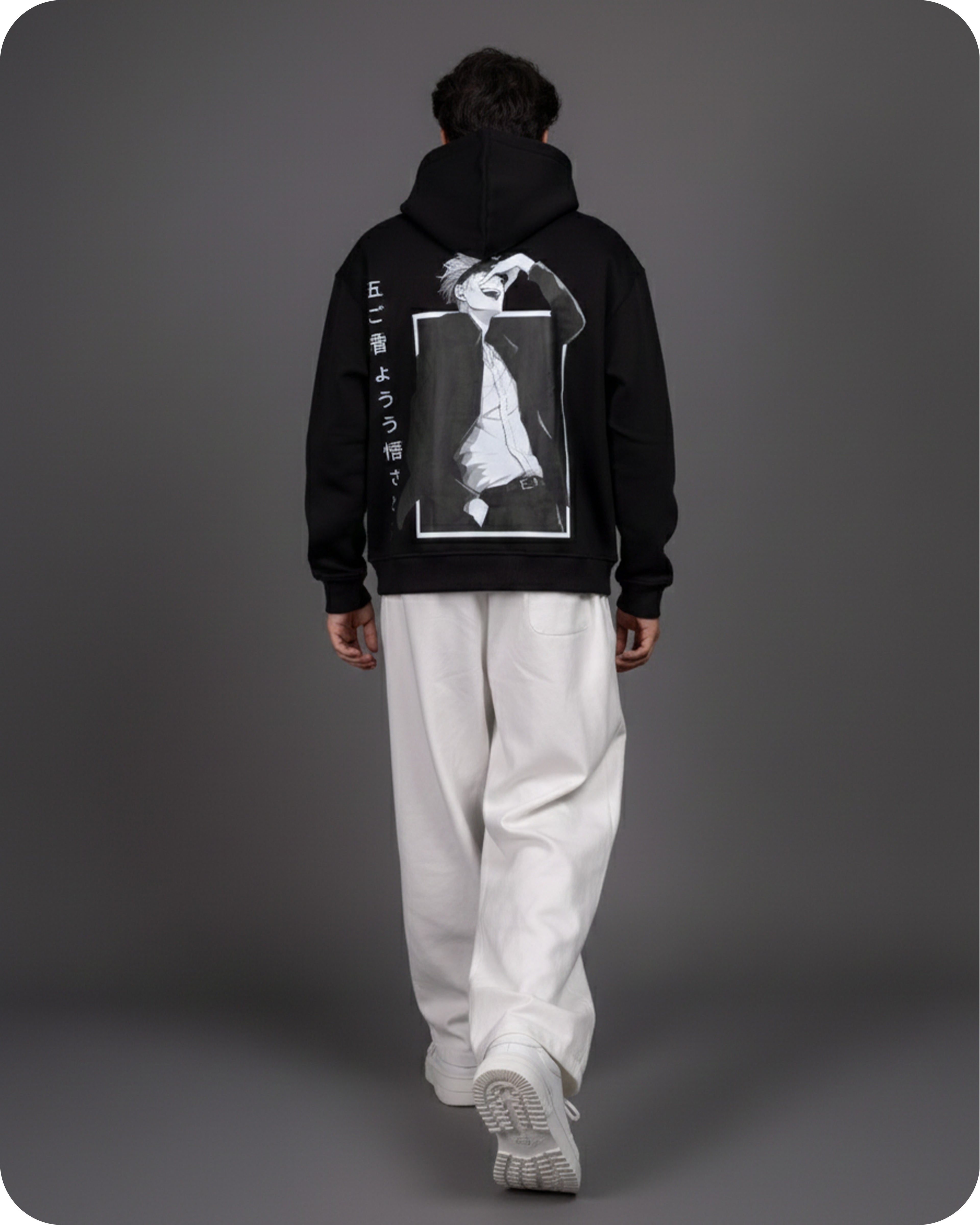 Person wearing a black hoodie with a graphic design on the back against a gray background