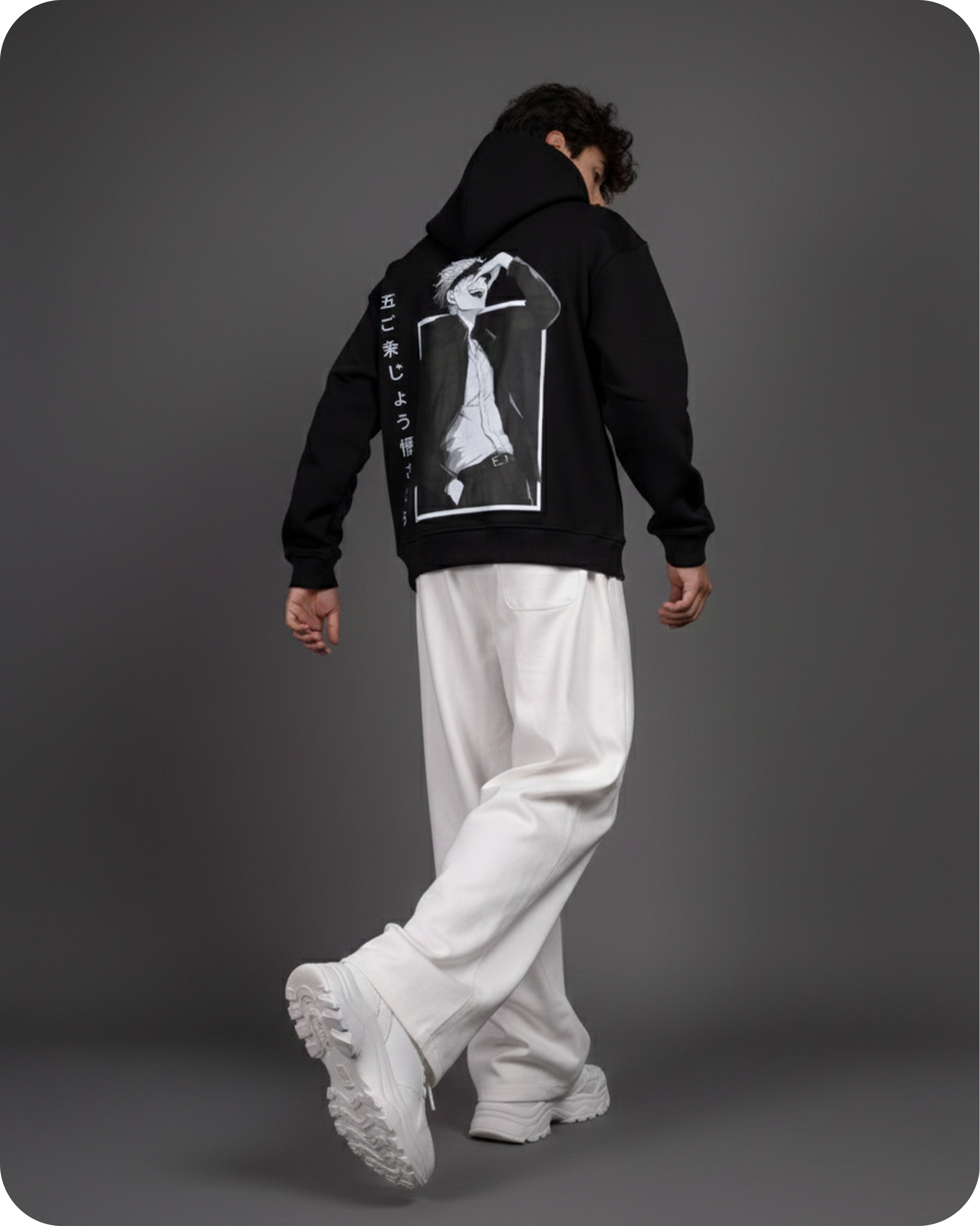 Person wearing a black hoodie with a graphic design on the back against a gray background