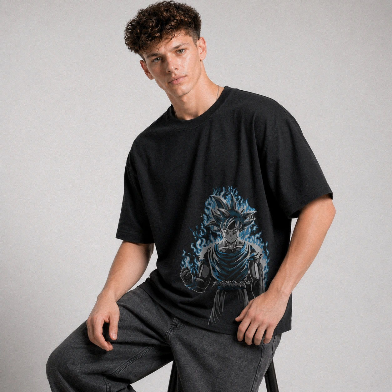 Person wearing a black t-shirt with a graphic design on a plain background