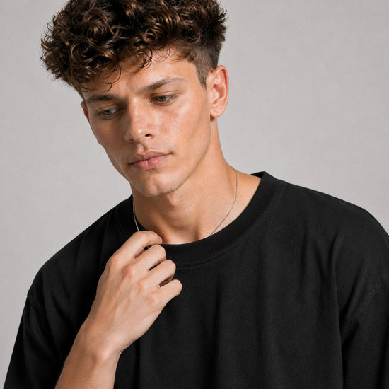Man wearing a black shirt against a gray background