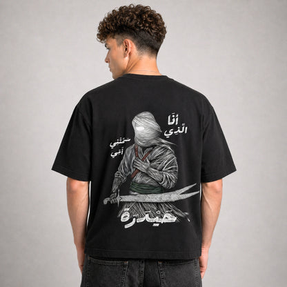 Person wearing a black t-shirt with a graphic design on the back against a gray background