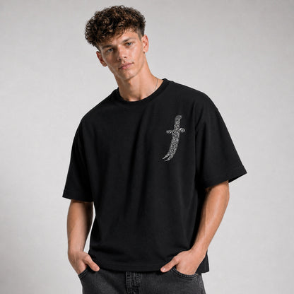Man wearing a black t-shirt with a small design on a gray background