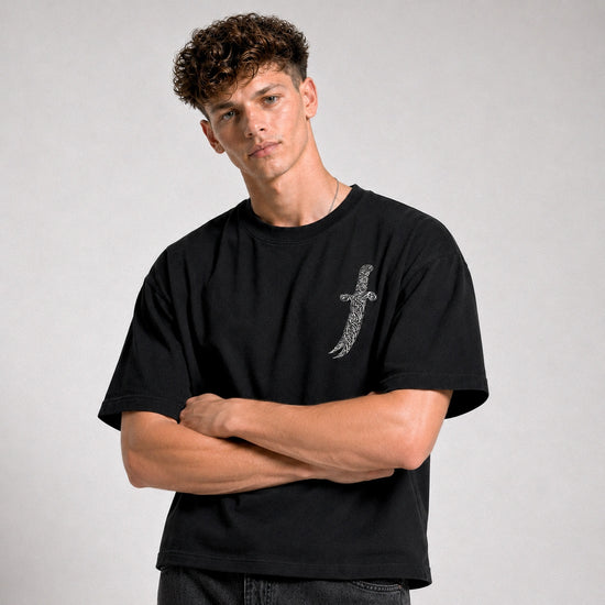 Man wearing a black t-shirt with a design on a plain background