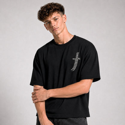 Man wearing a black t-shirt with a graphic design on a gray background