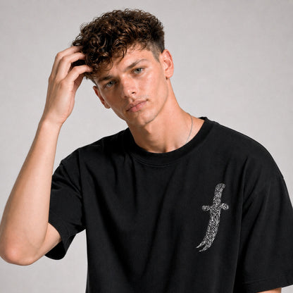 Man wearing a black t-shirt with a design on a gray background