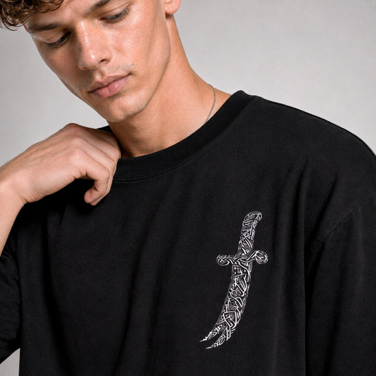 Person wearing a black sweatshirt with a white geometric design on a gray background