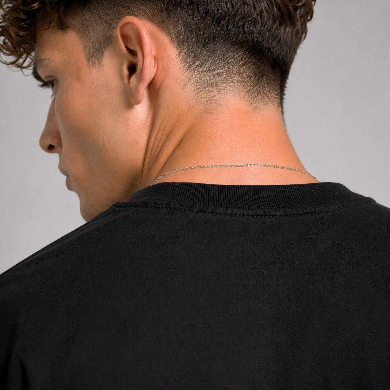 Man wearing a black shirt with a plain background