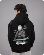 Person wearing a black hoodie with a graphic design on the back against a gray background