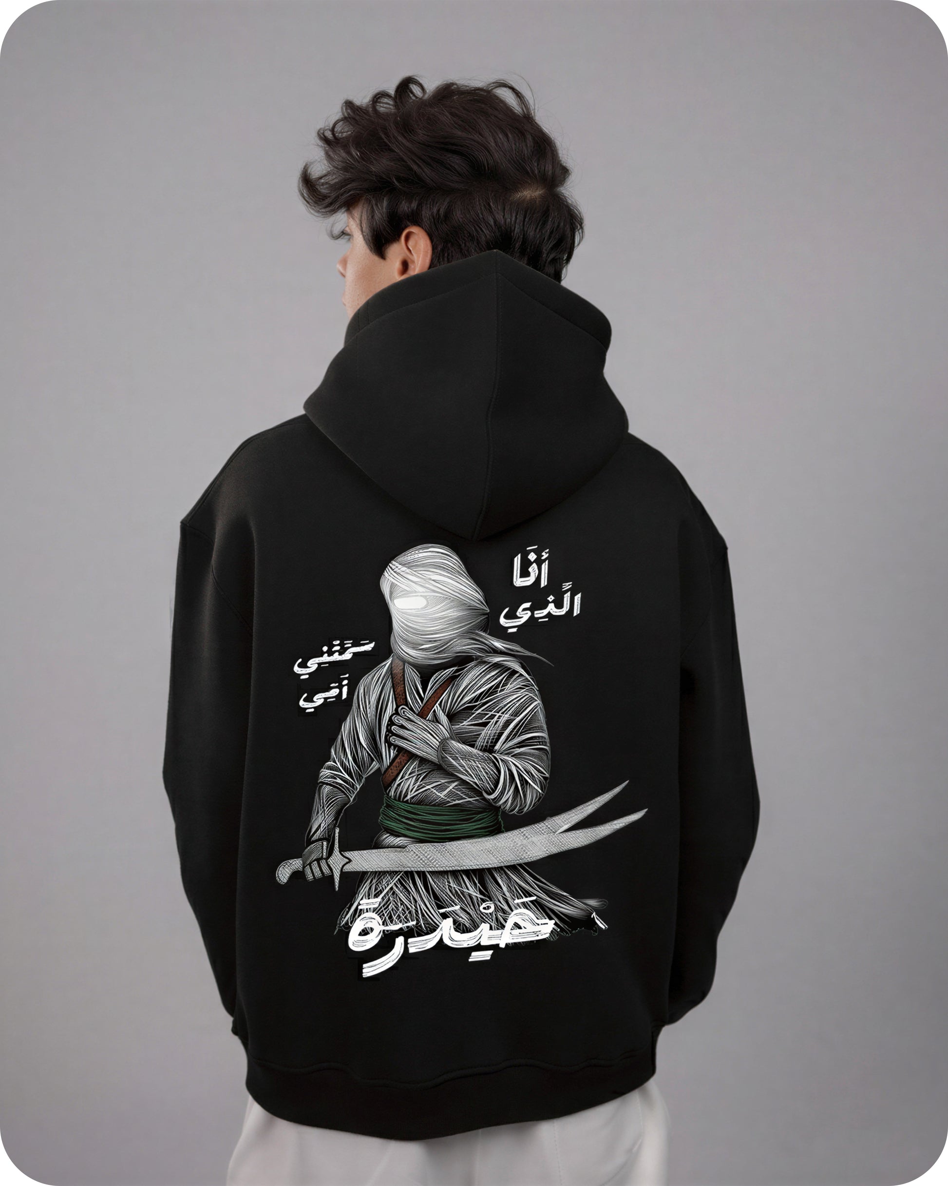 Person wearing a black hoodie with a graphic design on the back against a gray background