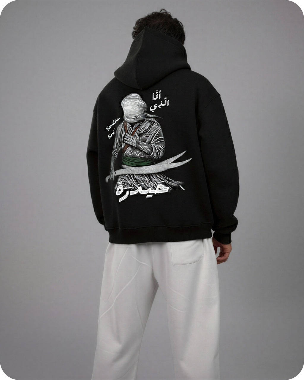 Person wearing a black hoodie with a graphic design on the back against a gray background