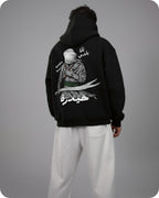 Person wearing a black hoodie with a graphic design on the back against a gray background