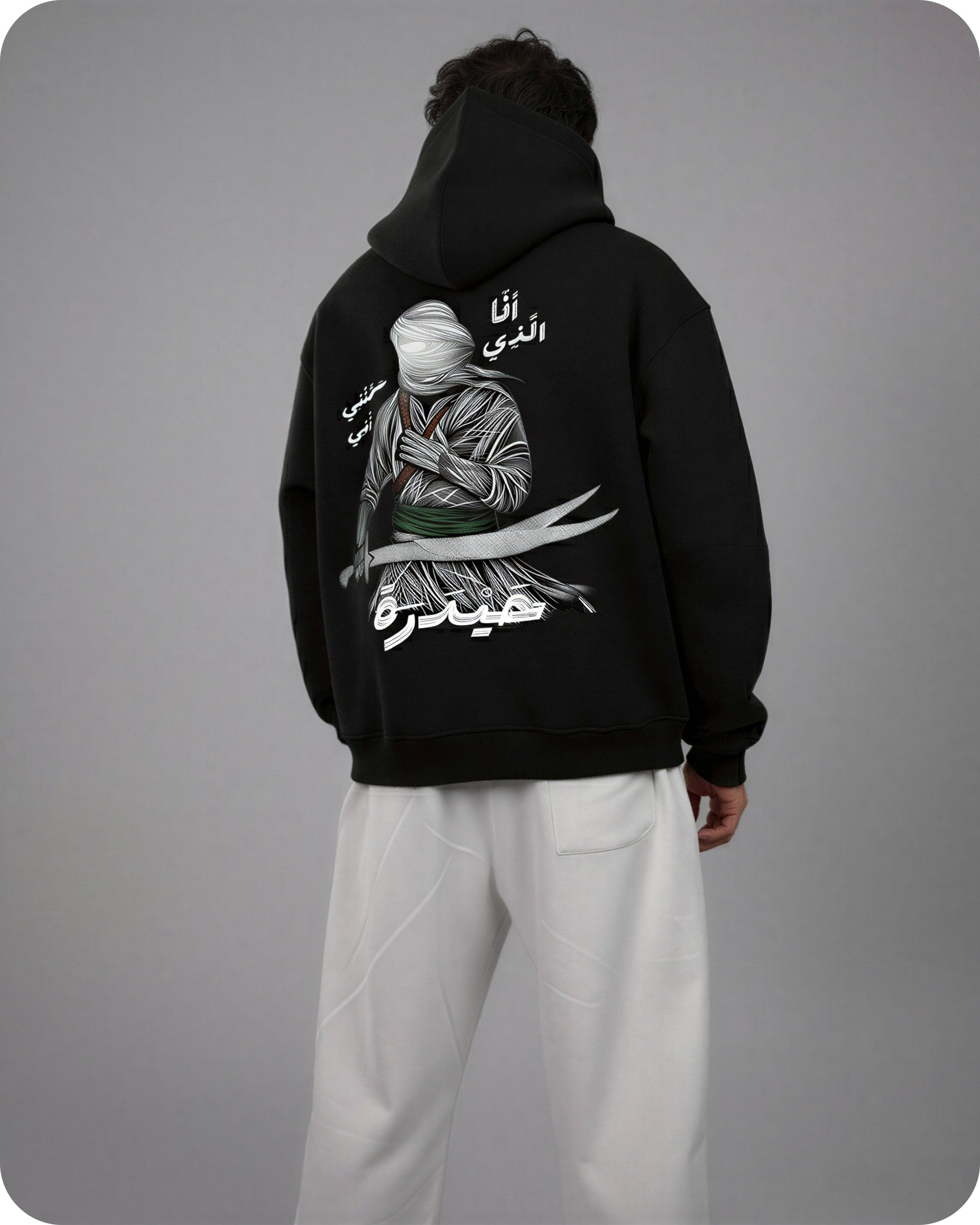 Person wearing a black hoodie with a graphic design on the back against a gray background
