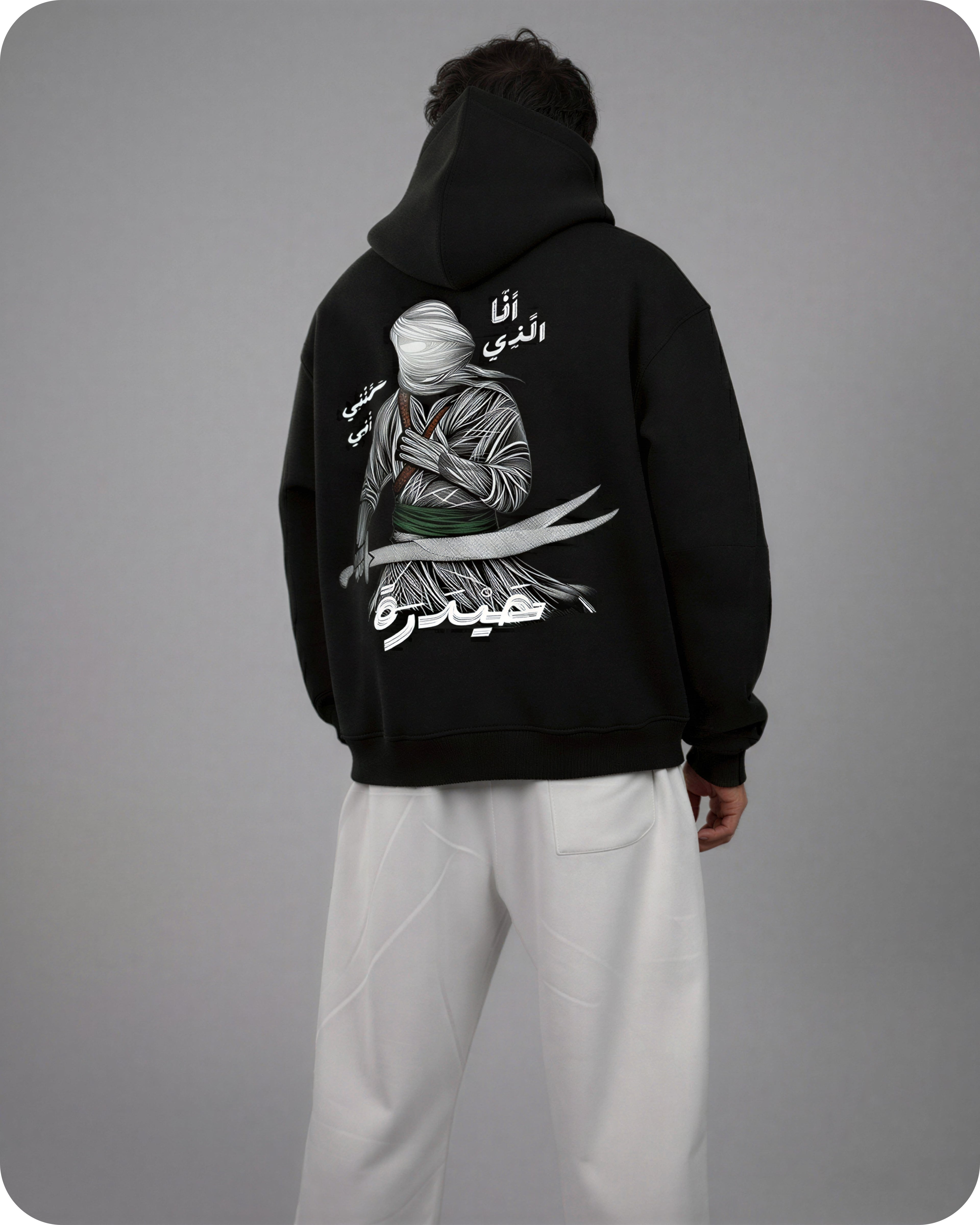 Person wearing a black hoodie with a graphic design on the back against a gray background