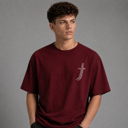 A man wearing a maroon t-shirt with a large graphic print of a bandit and Arabic text, shown from the back against a gray studio background.