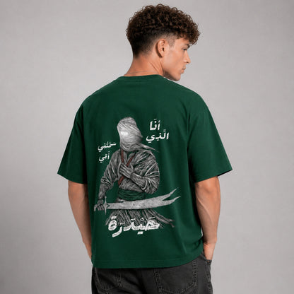 Person wearing a green t-shirt with a graphic design on the back against a gray background