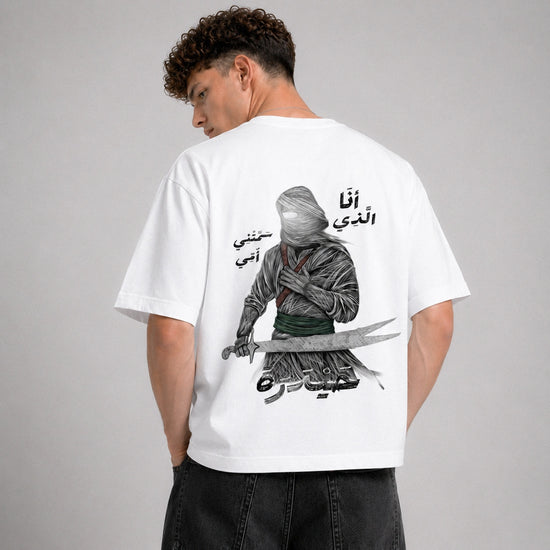 Person wearing a white t-shirt with a graphic design on the back against a gray background