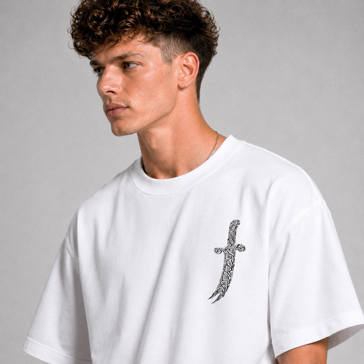 Man wearing a white t-shirt with a black design on a gray background