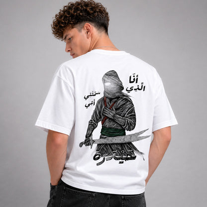 Person wearing a white t-shirt with a graphic design and text on the back, standing against a gray background.
