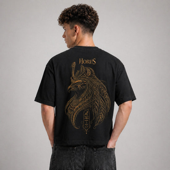 Person wearing a black t-shirt with gold 'Horus' design on the back against a gray background