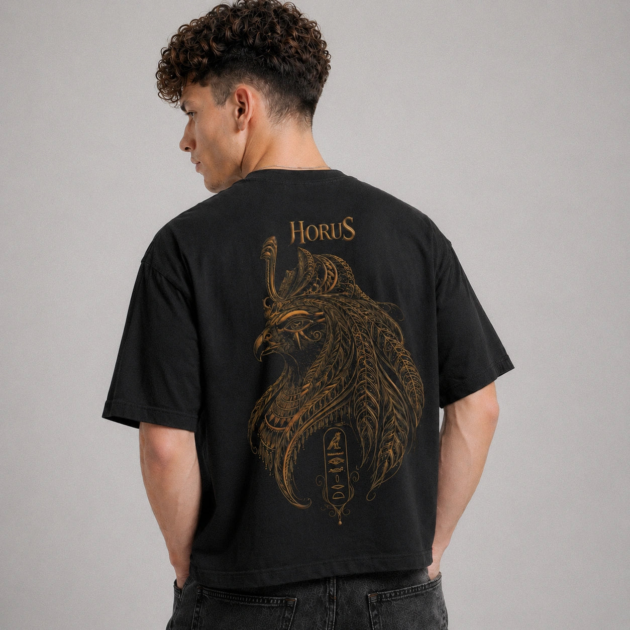 Person wearing a black t-shirt with a gold lion design and 'Horus' text on the back.