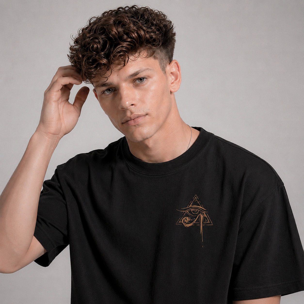Man wearing a black t-shirt with a logo on a gray background