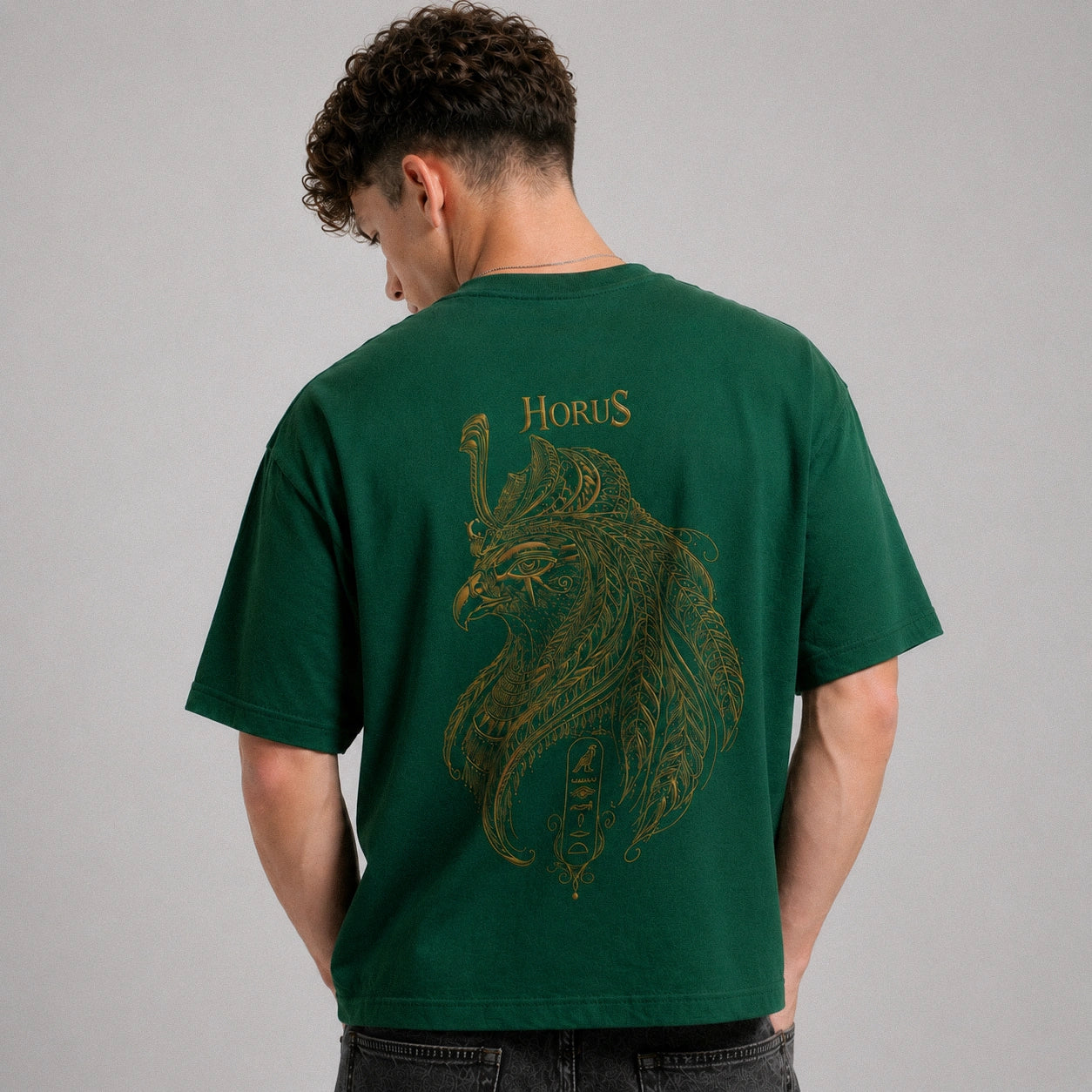 Person wearing a green t-shirt with a lion design and 'Horus' text on the back, against a gray background.