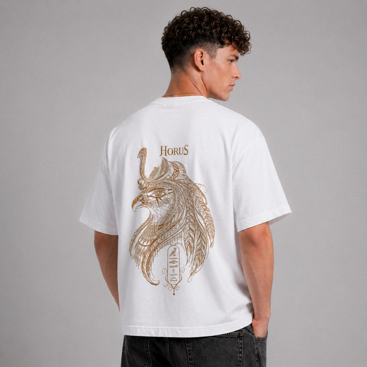 Person wearing a white t-shirt with a gold lion design and 'Horus' text on the back against a gray background