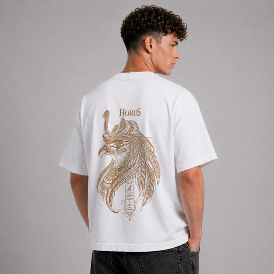 Person wearing a white t-shirt with a gold lion design and 'Horus' text on the back against a gray background