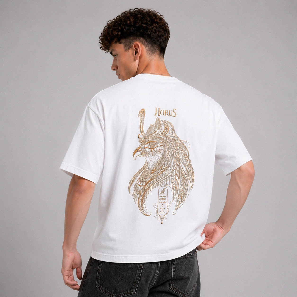 Person wearing a white t-shirt with a detailed design and 'Horus' text on the back, standing against a gray background.