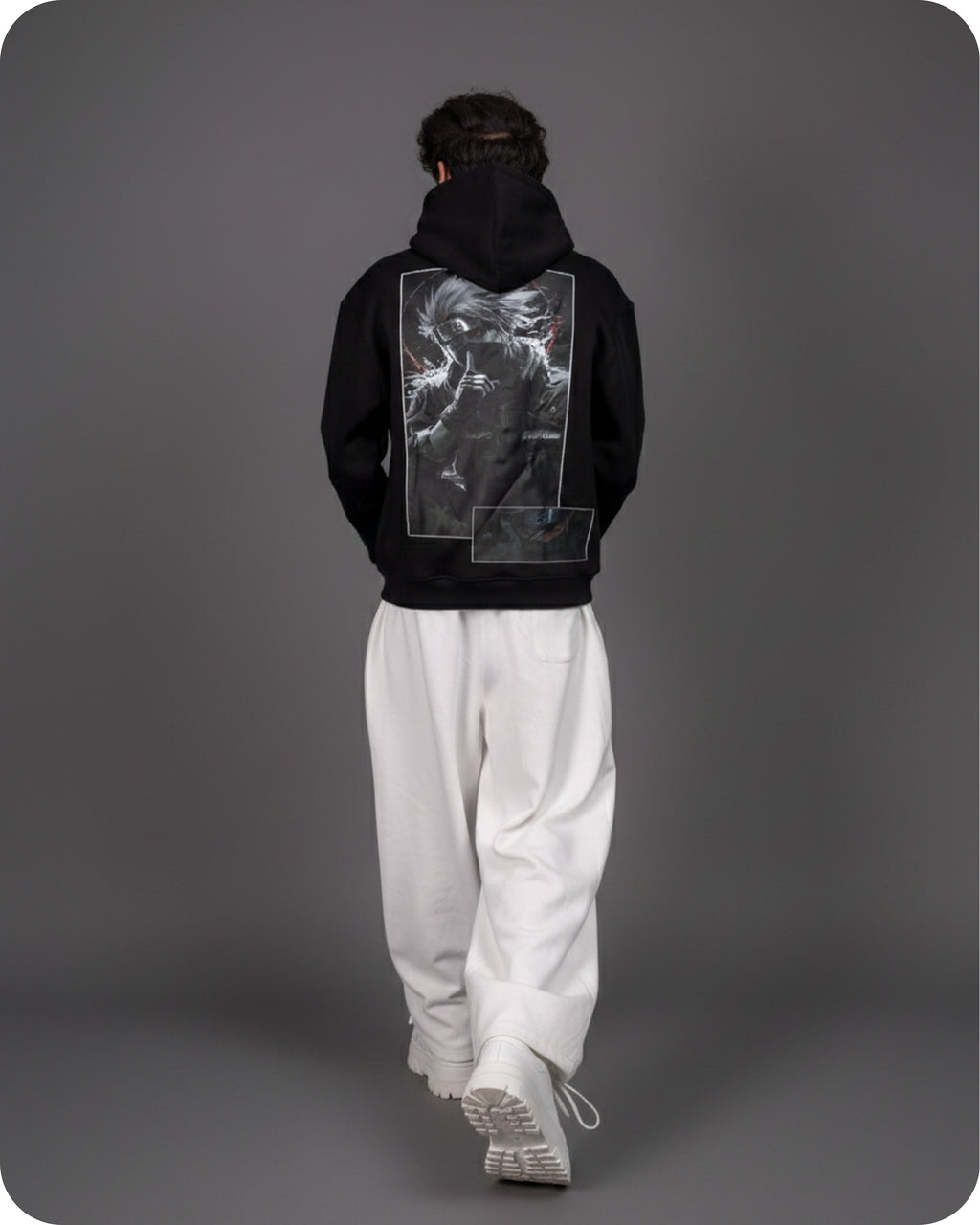 Person wearing a black hoodie with a graphic design on the back against a gray background