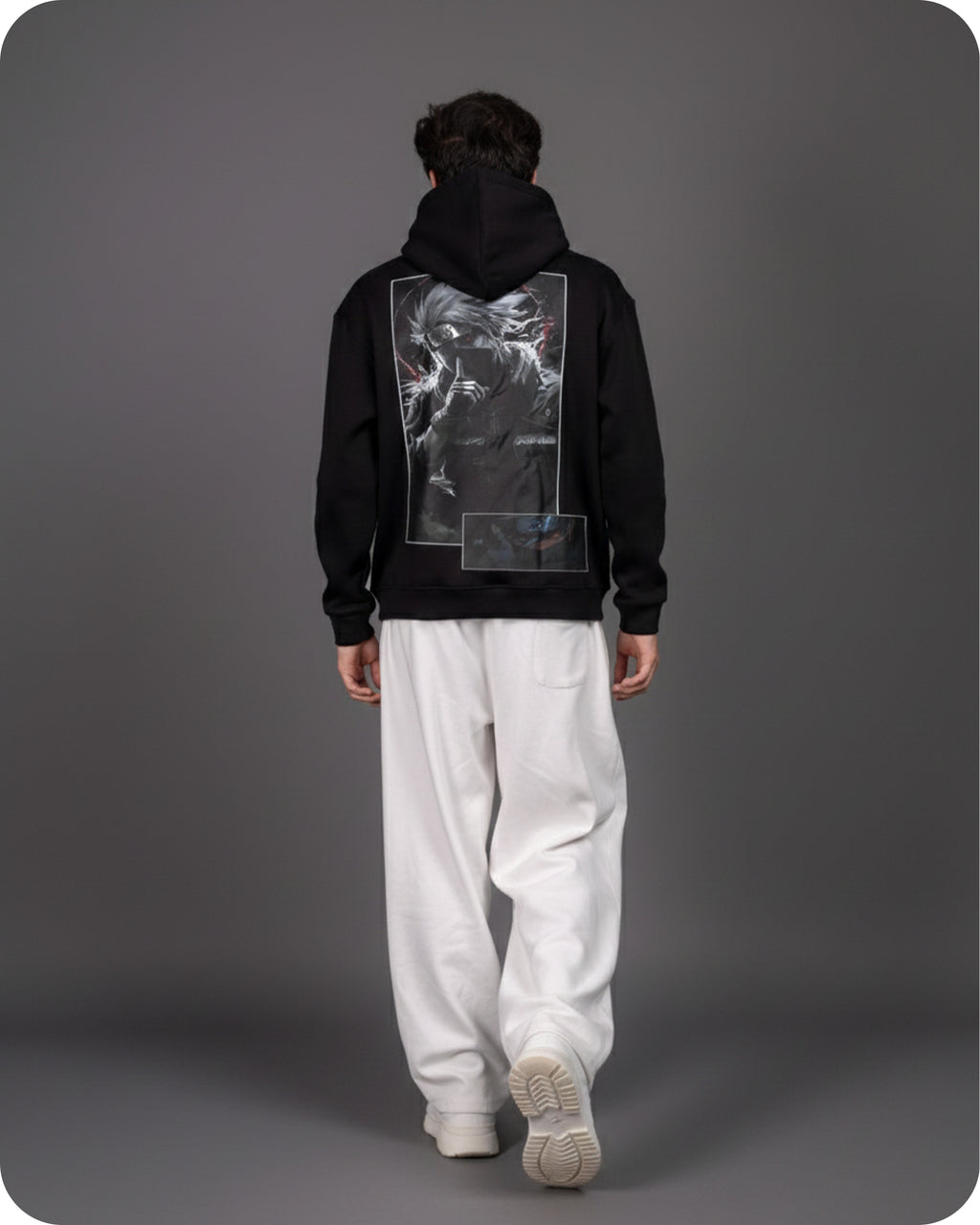 Person wearing a black hoodie with a unique design on the back against a gray background