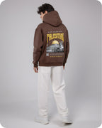 Person wearing a brown hoodie with 'Palestine' printed on the back, standing against a plain background.