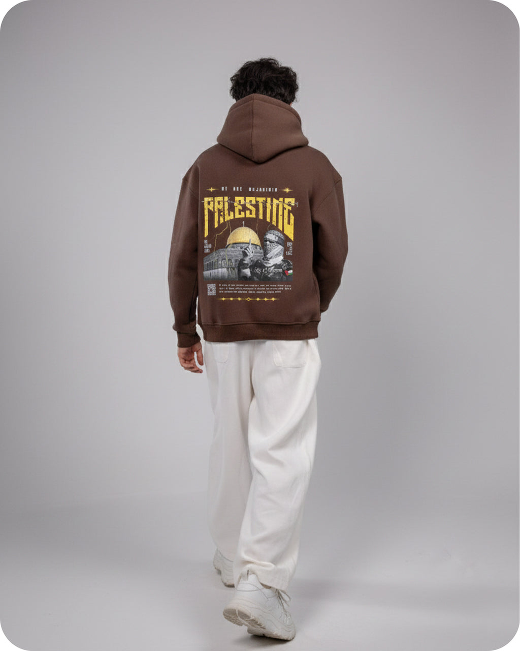 Person wearing a brown hoodie with graphic design on the back against a gray background