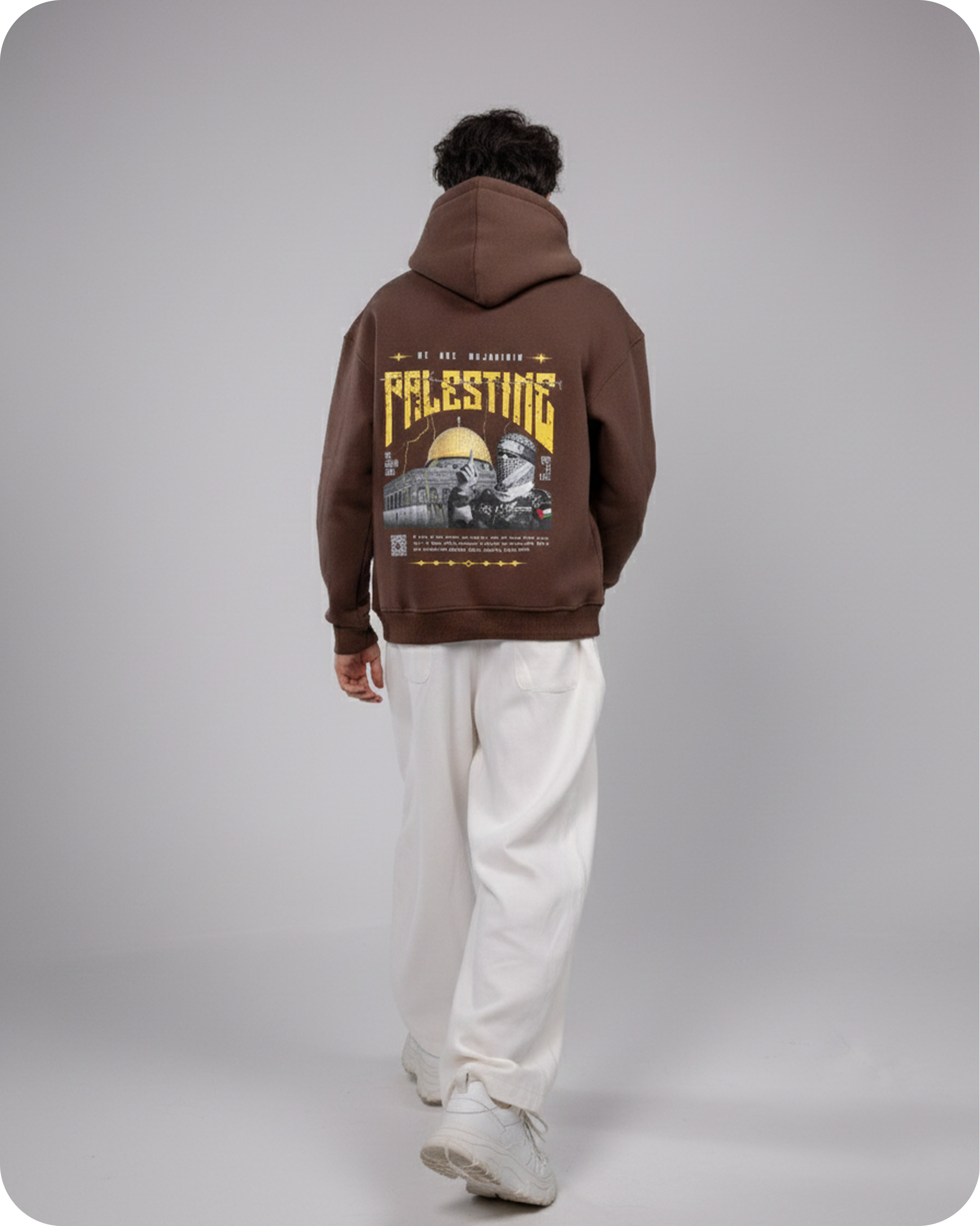 Person wearing a brown hoodie with graphic design on the back against a gray background