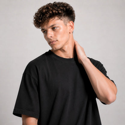 Man wearing a black t-shirt against a gray background