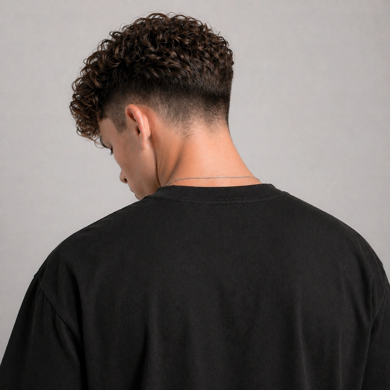 Person wearing a black shirt against a gray background