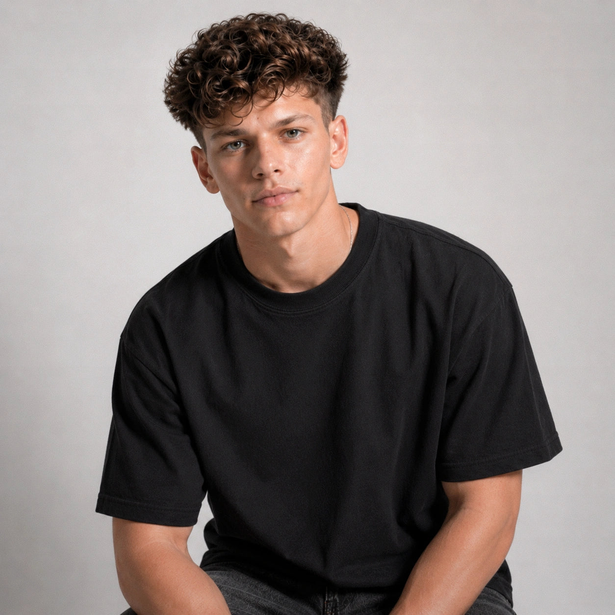 Man wearing a black t-shirt against a plain background