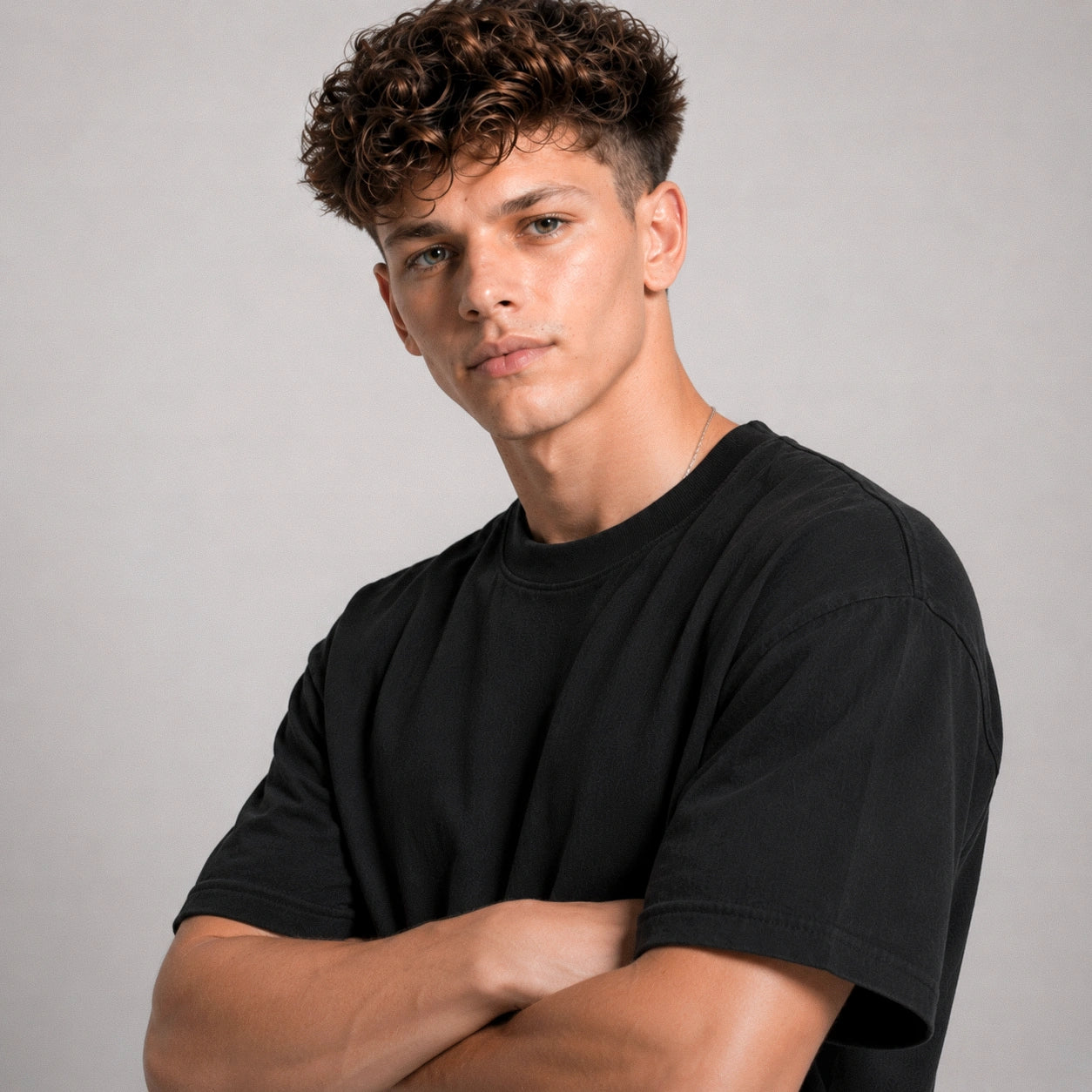 Man wearing a black t-shirt against a gray background